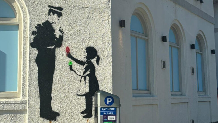 Stencil of child and police officer appears on Rockwater wall